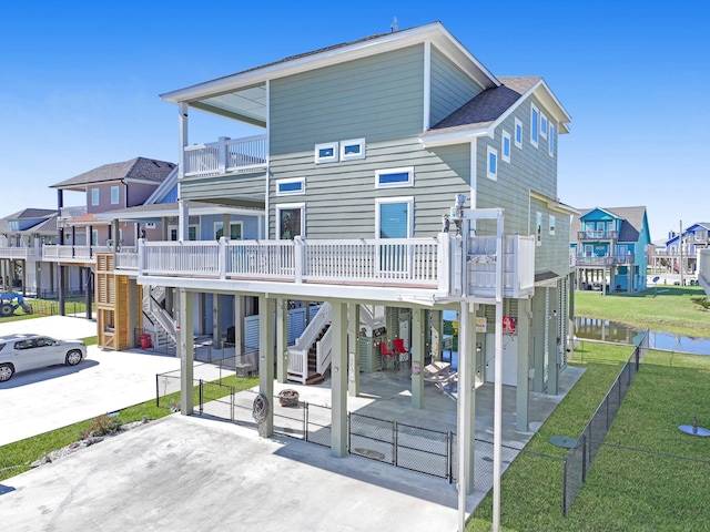 back of property featuring stairs, a carport, fence private yard, and a gate