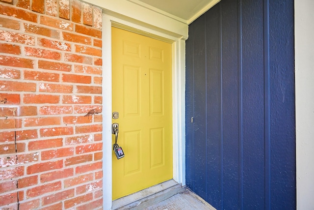 entrance to property with board and batten siding and brick siding