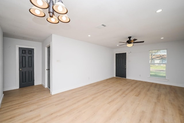 spare room featuring recessed lighting, visible vents, baseboards, light wood-style flooring, and ceiling fan with notable chandelier