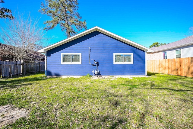 back of house featuring a lawn and a fenced backyard