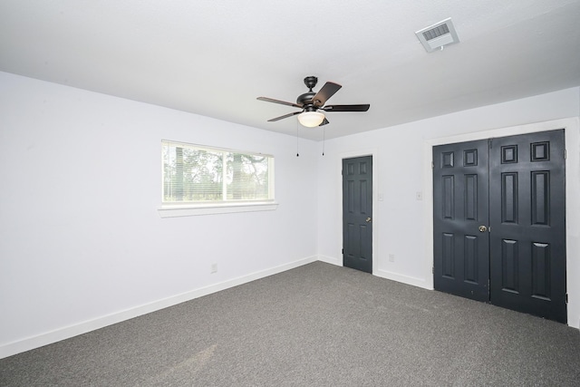 unfurnished bedroom with ceiling fan, visible vents, baseboards, a closet, and dark carpet