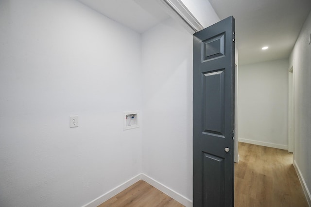 washroom with hookup for a washing machine, laundry area, light wood-style flooring, and baseboards