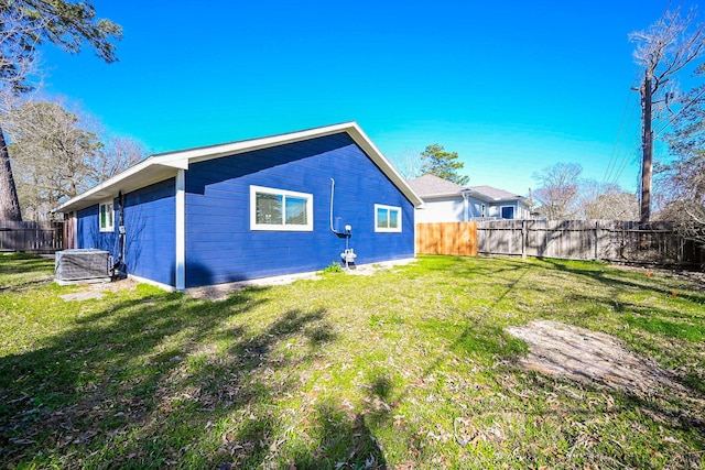 back of property featuring a fenced backyard, a lawn, and central air condition unit