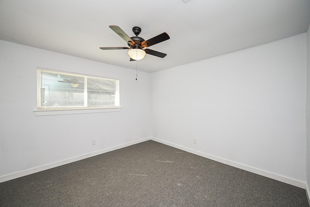 empty room featuring ceiling fan, dark carpet, and baseboards