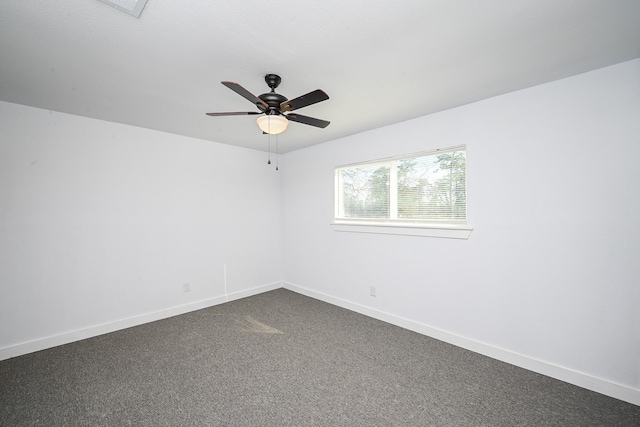unfurnished room featuring baseboards, dark carpet, and ceiling fan