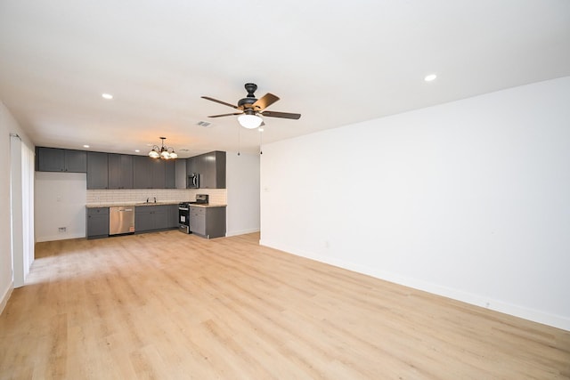 unfurnished living room with light wood finished floors, recessed lighting, visible vents, baseboards, and ceiling fan with notable chandelier