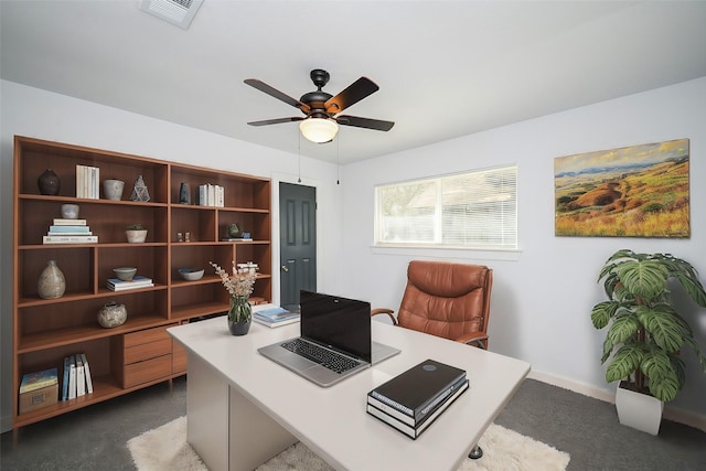home office with baseboards, dark carpet, visible vents, and a ceiling fan