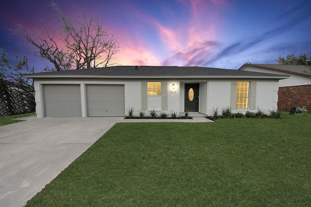 single story home featuring brick siding, a yard, a shingled roof, a garage, and driveway