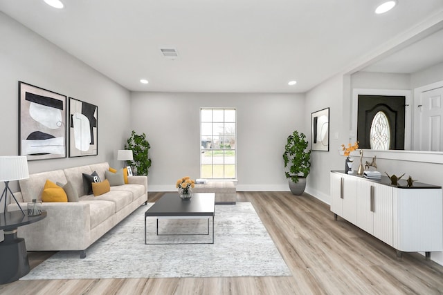 living area with baseboards, light wood finished floors, visible vents, and recessed lighting