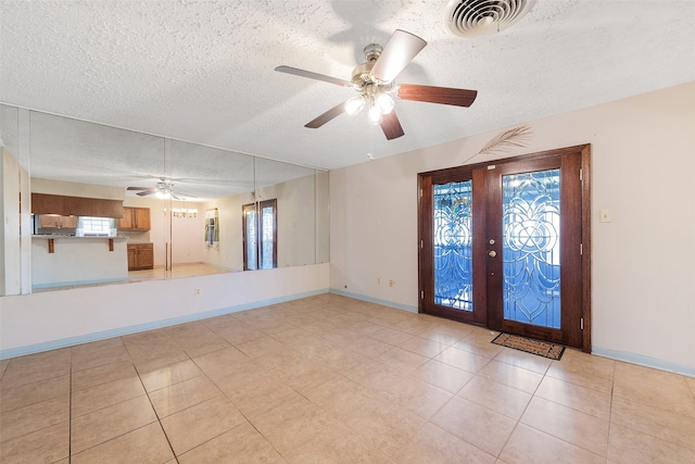 spare room with french doors, visible vents, a textured ceiling, and baseboards