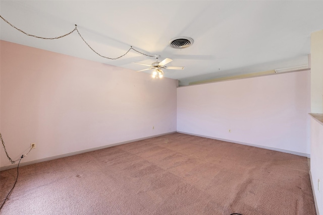 empty room with a ceiling fan, visible vents, light carpet, and baseboards