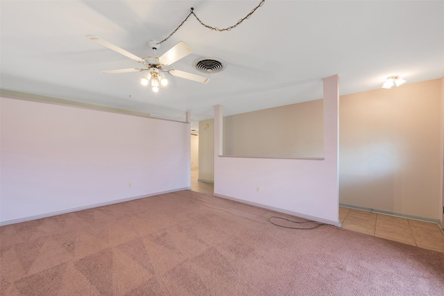 spare room featuring ceiling fan, baseboards, visible vents, and light colored carpet