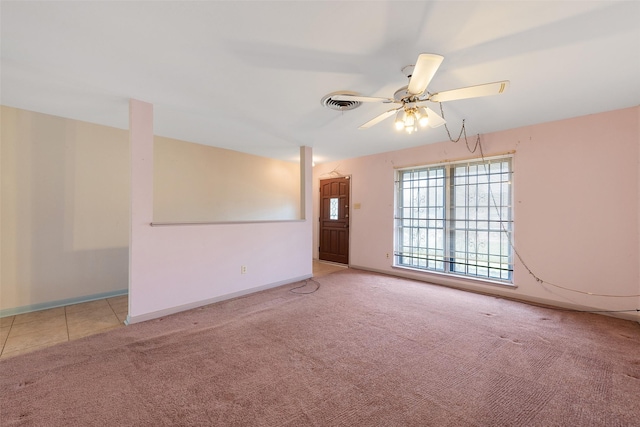 empty room featuring a ceiling fan, carpet flooring, visible vents, and baseboards