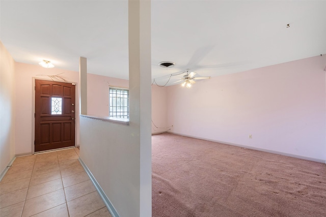 foyer with light tile patterned floors, light colored carpet, visible vents, ceiling fan, and baseboards