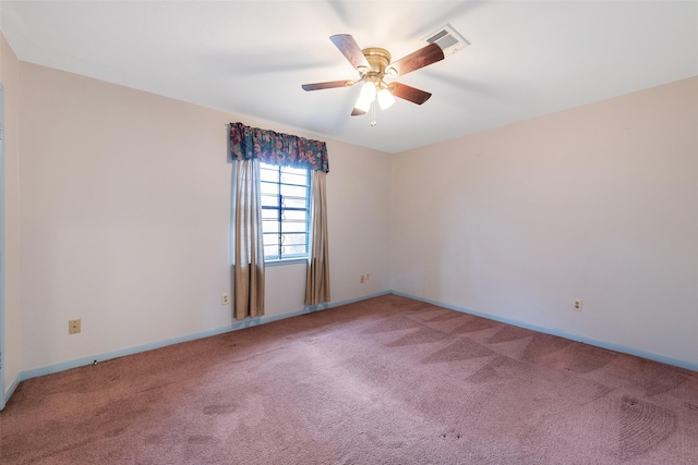 spare room with baseboards, carpet floors, visible vents, and a ceiling fan