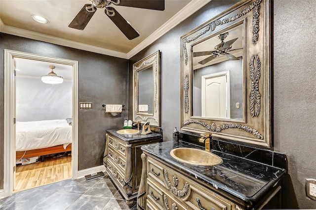 ensuite bathroom with a sink, two vanities, ornamental molding, and a ceiling fan