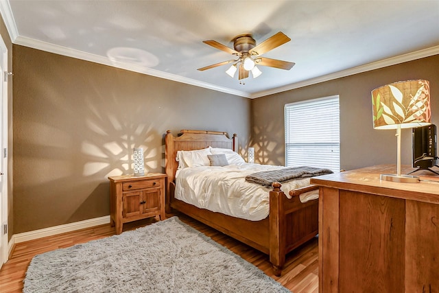 bedroom with light wood-style flooring, crown molding, and baseboards