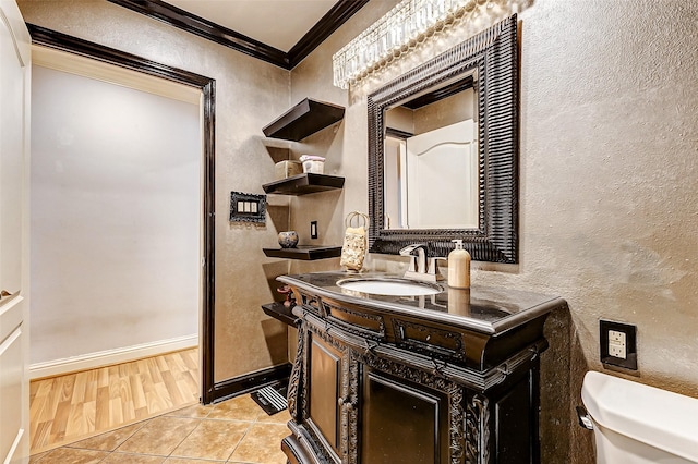 half bathroom featuring toilet, crown molding, tile patterned flooring, baseboards, and a textured wall