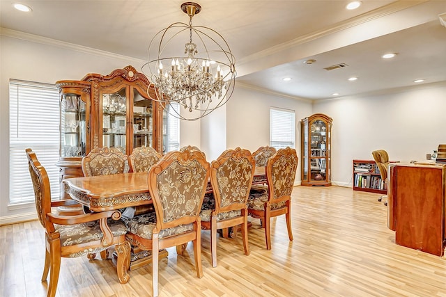 dining room featuring visible vents, a notable chandelier, crown molding, and light wood finished floors