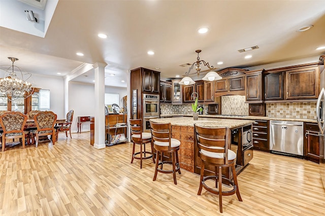 kitchen featuring stainless steel appliances, dark brown cabinetry, an island with sink, and light wood finished floors