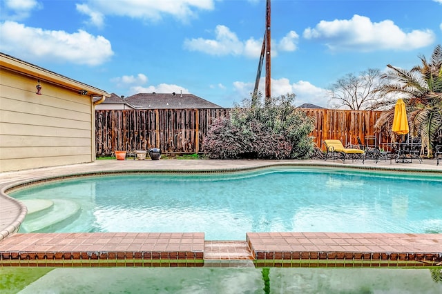 view of pool featuring a patio, a fenced backyard, and a pool with connected hot tub