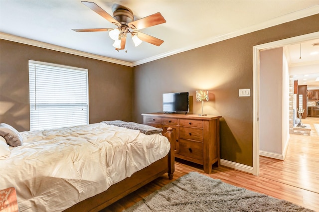 bedroom with baseboards, attic access, ceiling fan, ornamental molding, and light wood-type flooring