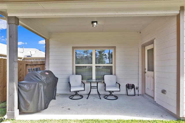 view of patio featuring a grill and fence