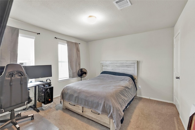 bedroom with baseboards, a textured ceiling, visible vents, and carpet flooring