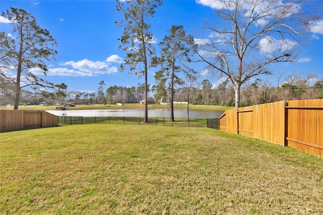 view of yard with a water view and a fenced backyard