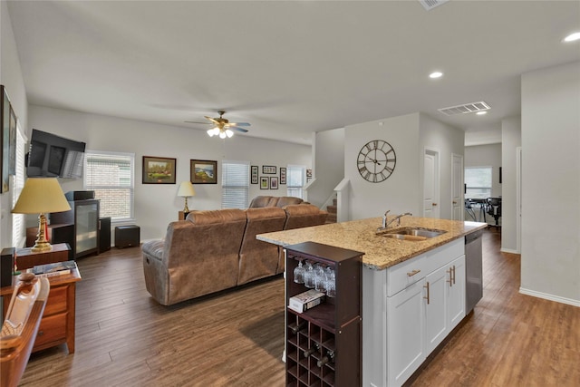 kitchen with a sink, visible vents, white cabinets, dishwasher, and dark wood finished floors