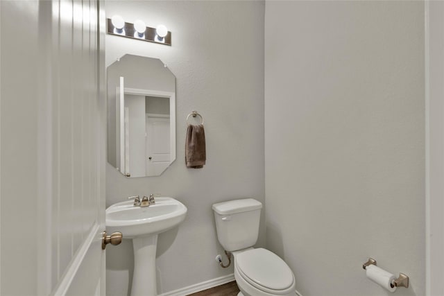 bathroom with toilet and baseboards