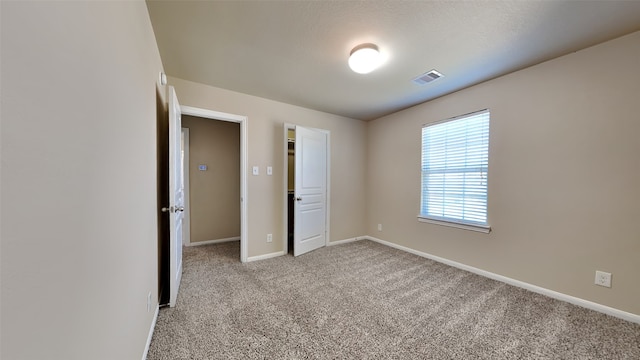 unfurnished bedroom featuring carpet, visible vents, and baseboards