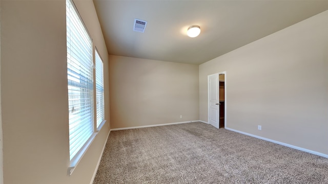 carpeted empty room with visible vents and baseboards