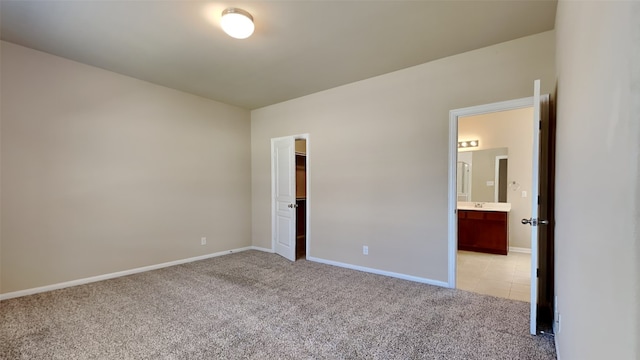 empty room featuring light carpet and baseboards