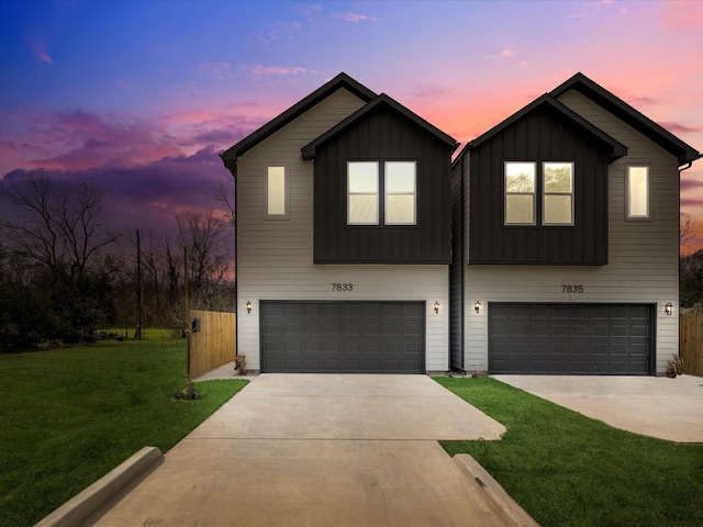 modern inspired farmhouse with an attached garage, concrete driveway, board and batten siding, and a front yard