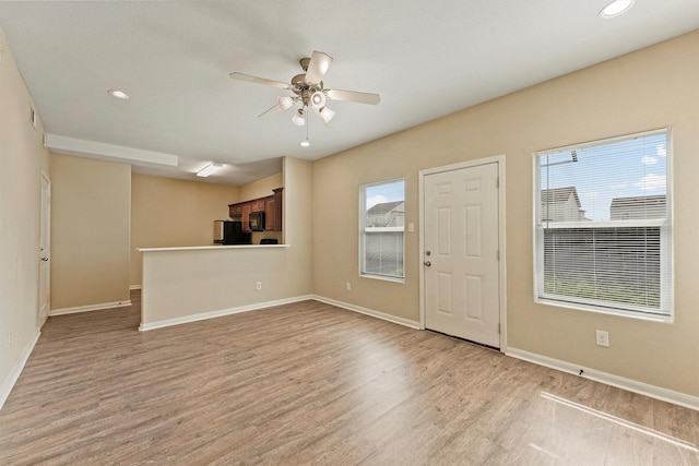 interior space with light wood-type flooring, ceiling fan, baseboards, and recessed lighting