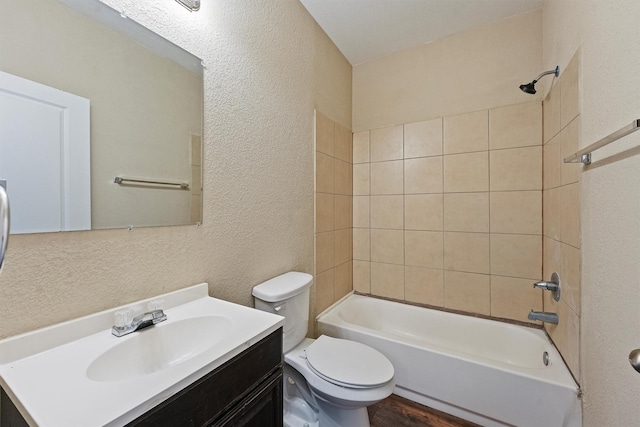 full bathroom featuring shower / tub combination, a textured wall, vanity, and toilet