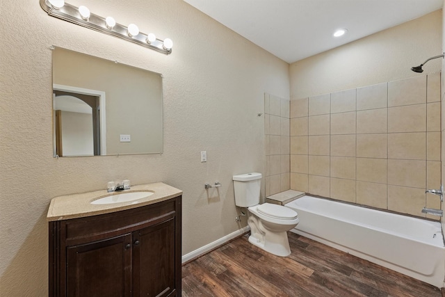 full bath with shower / bathtub combination, toilet, wood finished floors, vanity, and baseboards