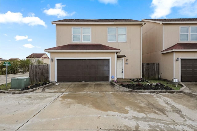 view of front of house featuring a garage, fence, and concrete driveway