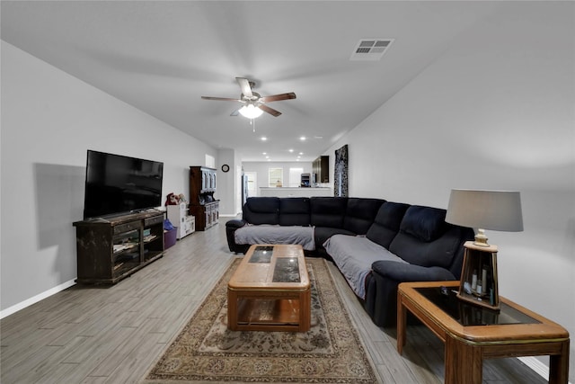 living area with light wood-style flooring, visible vents, ceiling fan, and baseboards