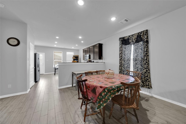 dining space featuring baseboards, light wood-style flooring, visible vents, and recessed lighting