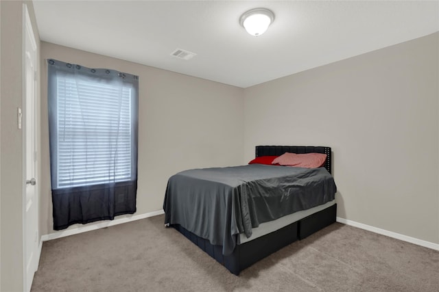 carpeted bedroom featuring visible vents and baseboards