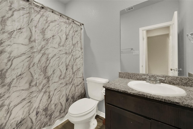 bathroom with curtained shower, visible vents, toilet, vanity, and wood finished floors