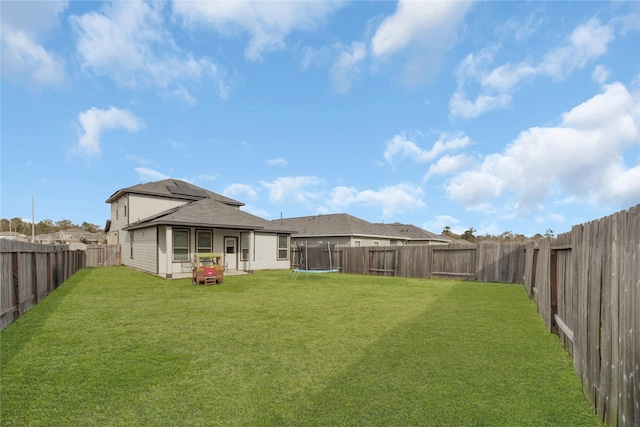 view of yard featuring a trampoline and a fenced backyard