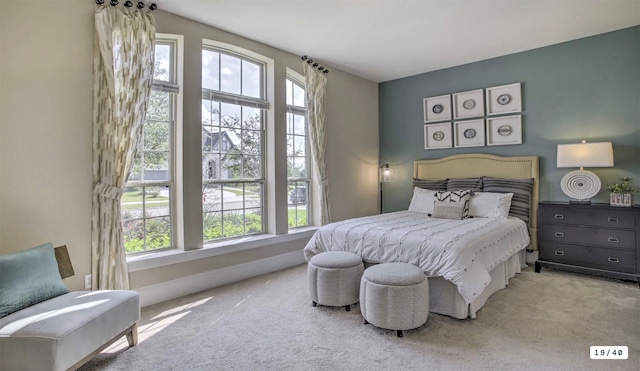 carpeted bedroom with multiple windows and baseboards