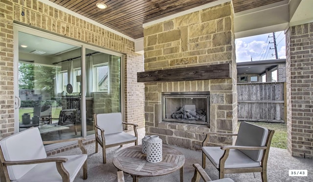 view of patio / terrace featuring an outdoor stone fireplace and fence