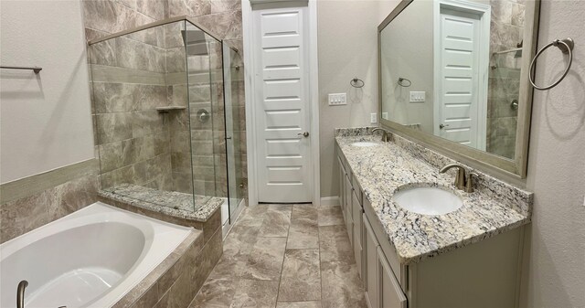 bathroom featuring a sink, a stall shower, double vanity, and a bath