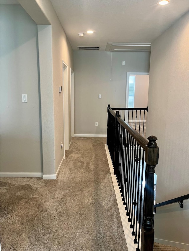 corridor featuring attic access, an upstairs landing, baseboards, and visible vents