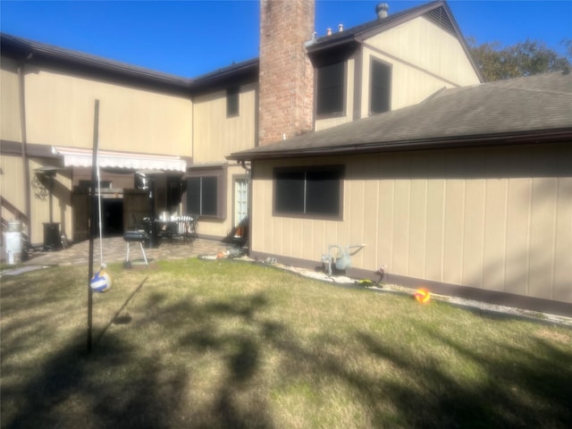 8111 Ivan Reid Dr, Houston, TX 77040 - rear view of property with a chimney, a patio area, a yard, and a shingled roof