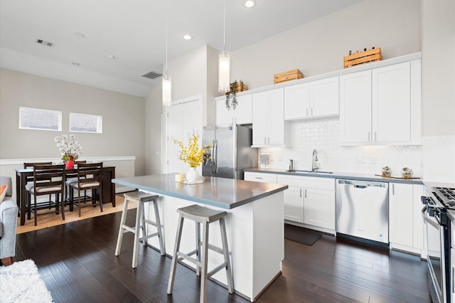 kitchen with visible vents, a breakfast bar area, stainless steel appliances, and a sink